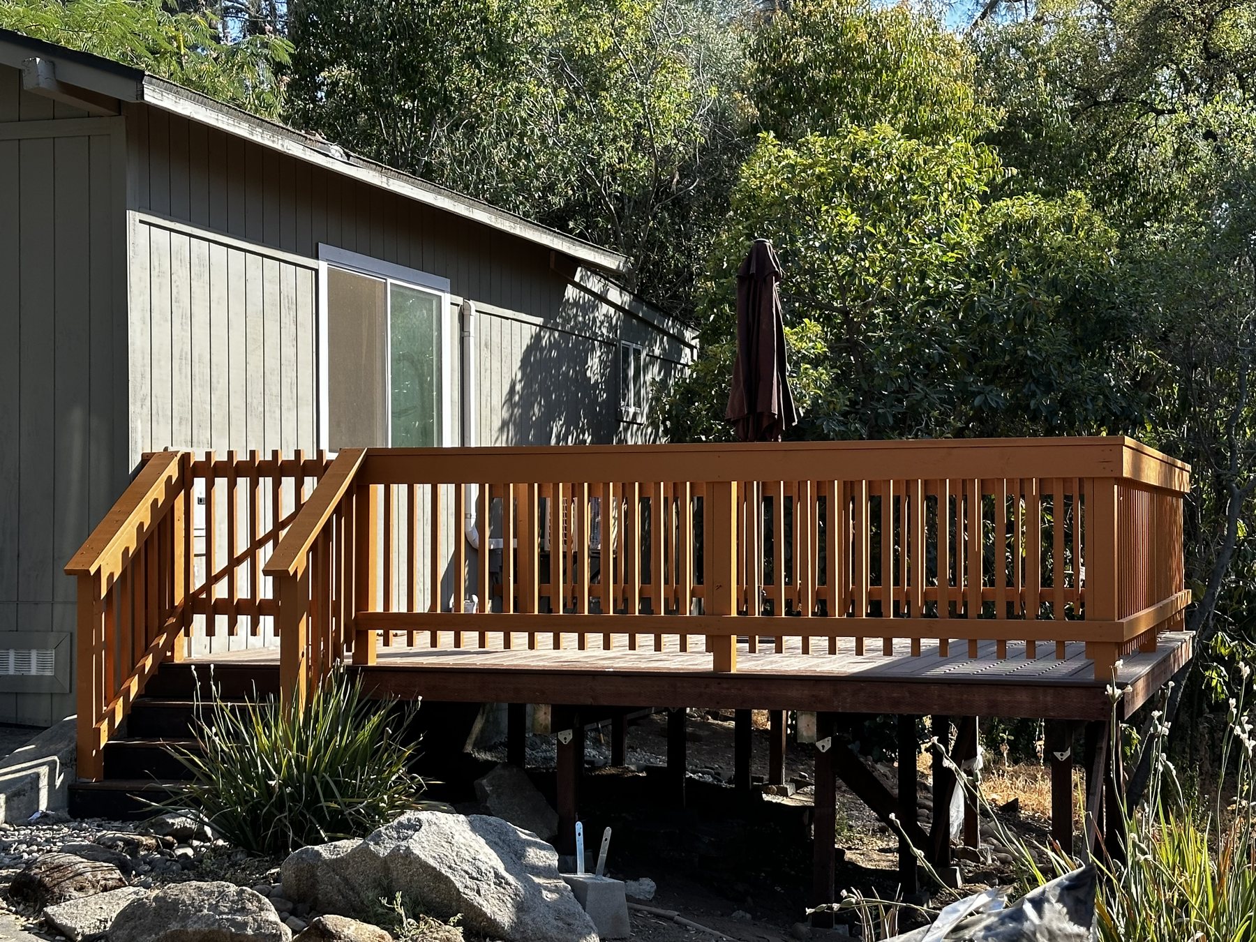 A finished redwood deck built into a granite boulder outcrop by AJ Construction